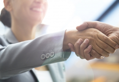 Two business people shaking hands and smiling
