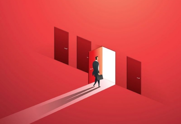 Businessman walking through open door along red wall of doors